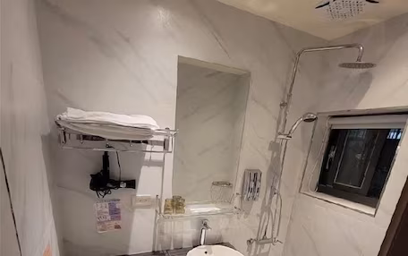 A compact bathroom with a toilet, sink, and shower.