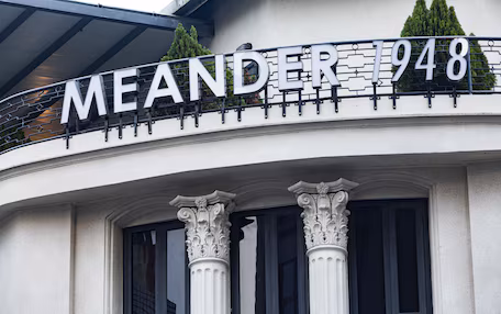 A building with the name "MEANDER 1948" on a balcony.